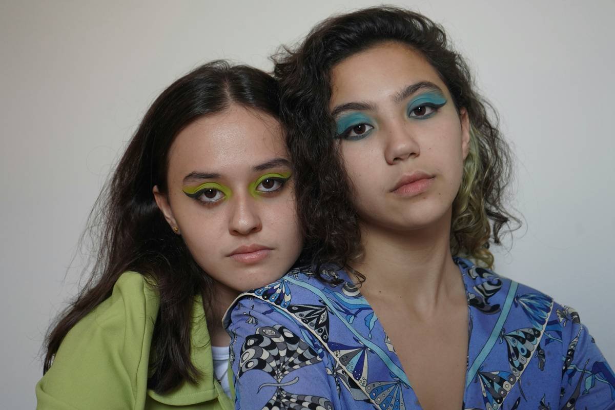 Side-by-side swatches showing regular cosmetic eyeshadow vs. professional stage makeup palette under stage lighting; stage version retains vibrancy, cosmetic version fades and oxidizes