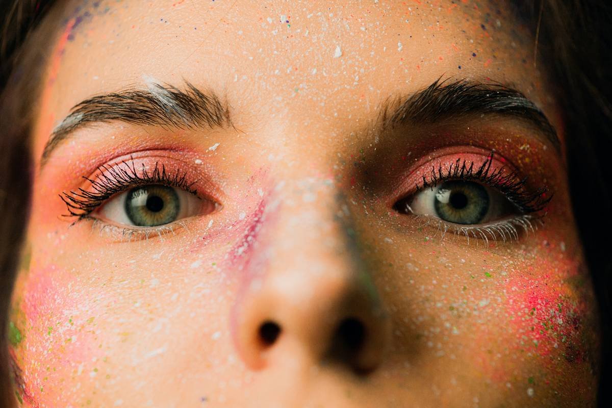 Close-up of expressive makeup designs featuring tear-like crystals and feathered eyeliner